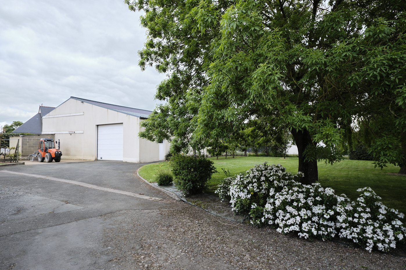 Entrée et jardin d'un domaine viticole menant vers un chai