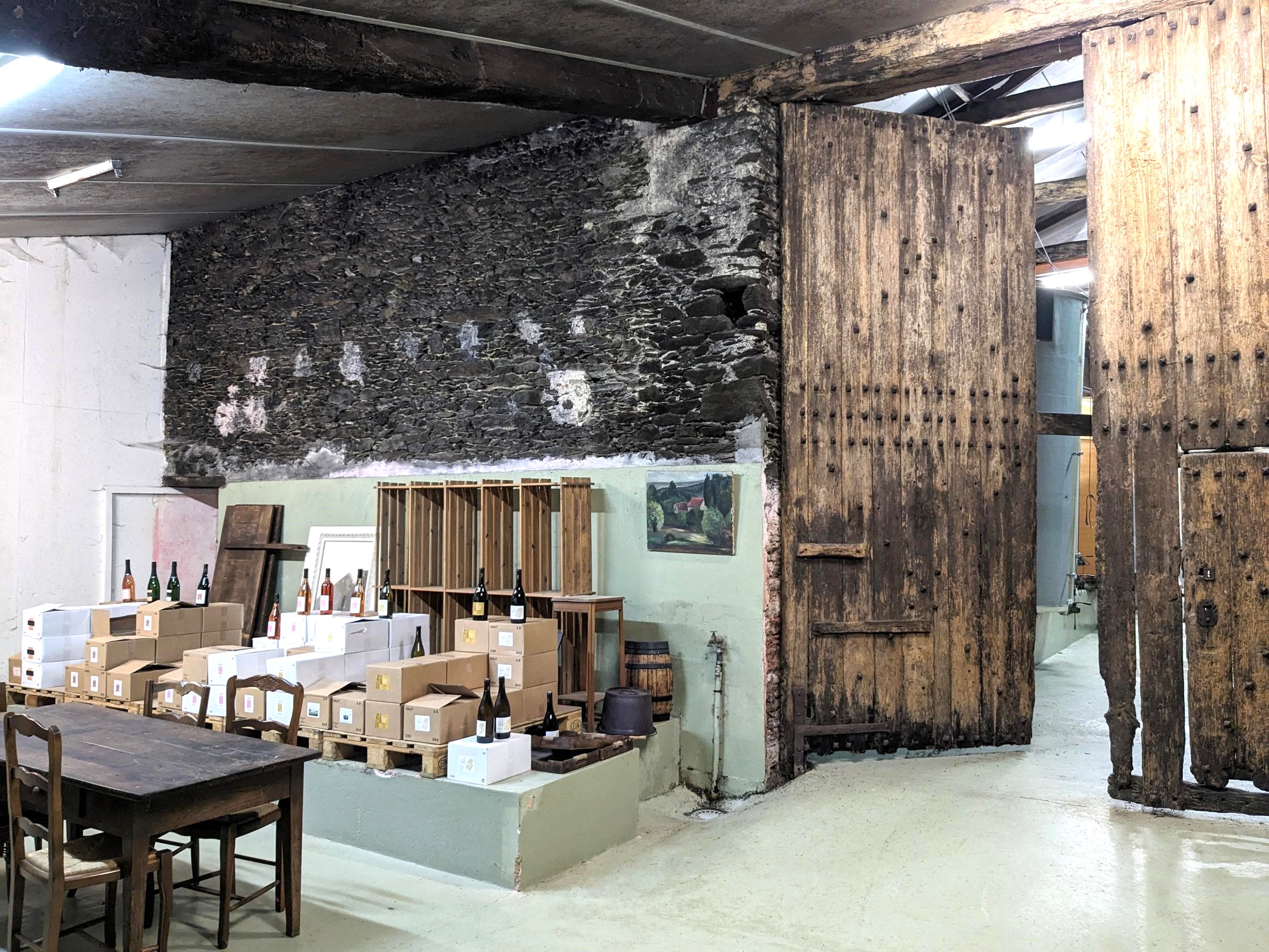 Salle de dégustation d'un domaine viticole en muscadet avec une grande porte en bois