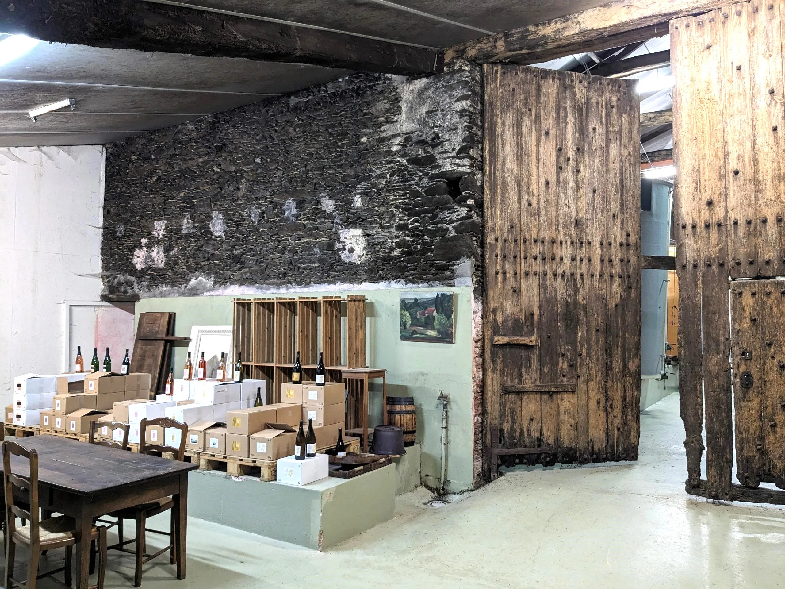 Salle de dégustation d'un domaine viticole en muscadet avec une grande porte en bois