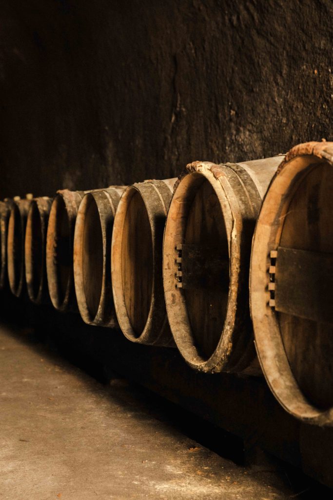 Alignement de barriques en bois dans une cave troglodyte