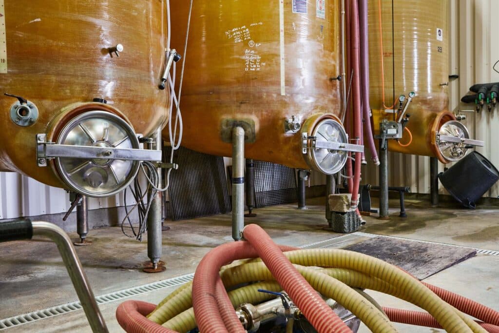 Cuves de vinification dans un chai, illustrant les installations techniques d’un domaine viticole.